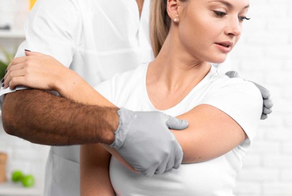 Fisio trata el hombro de una mujer antes de recubrimiento poroso para implantes